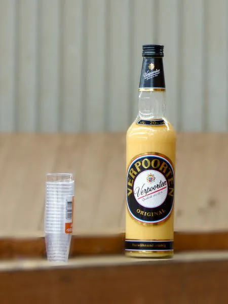 Eine Flasche Eierlilkör mit Pinnchen steht auch Reithallenbande.