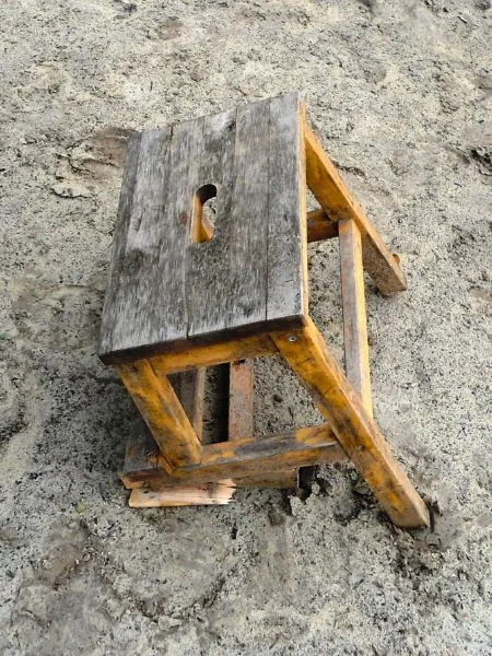 Ein gebrochener Holzhocker auf dem Reitplatz.