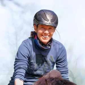 Angstfrei Reiten in einem Tag: Eine Frau sitzt mit breitem Grinsen auf einem Pferd.